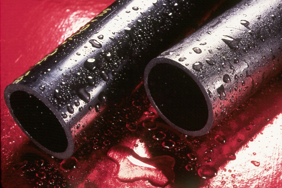 Abspipe | Reedy Chemical Foam Two black rubber hoses with water droplets lying on a red surface