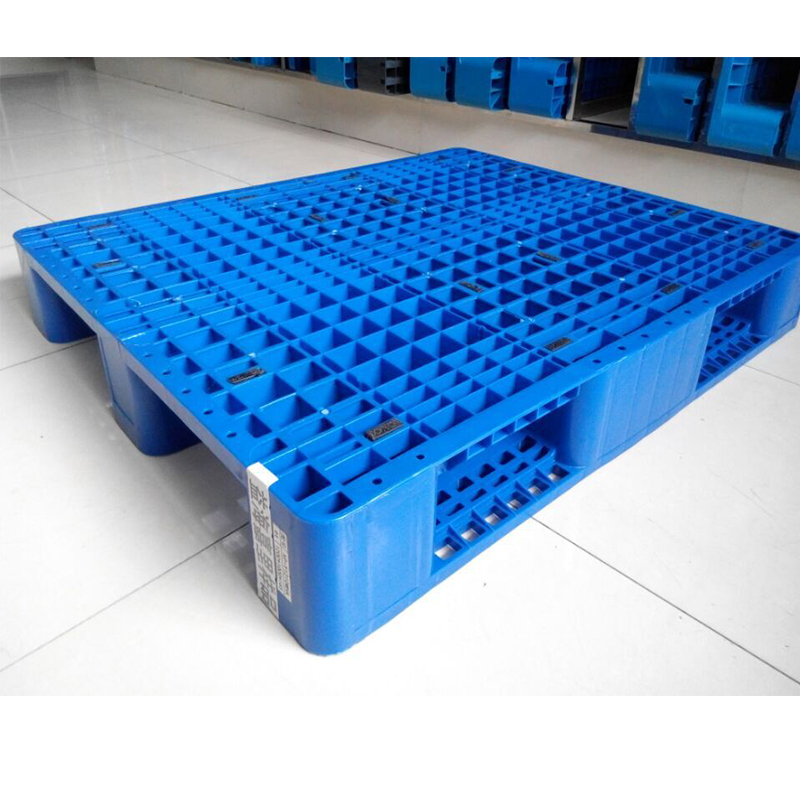 Pallet | Reedy Chemical Foam Blue plastic pallet on a white tiled floor, showing a grid of square depressions and hollow sides for forklift entry at the edges.