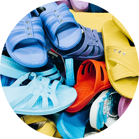 Vector 3-shoes | Reedy Chemical Foam Pile of colorful plastic sandals and slides in blue, yellow, red, teal, and more.