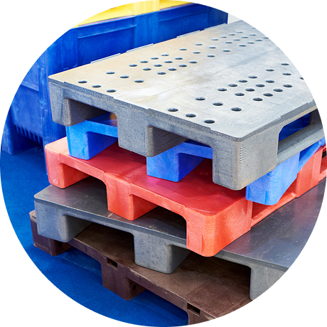 Vector 4-platform | Reedy Chemical Foam Stack of colorful plastic pallets in gray, red, and blue for storage in a warehouse setting.